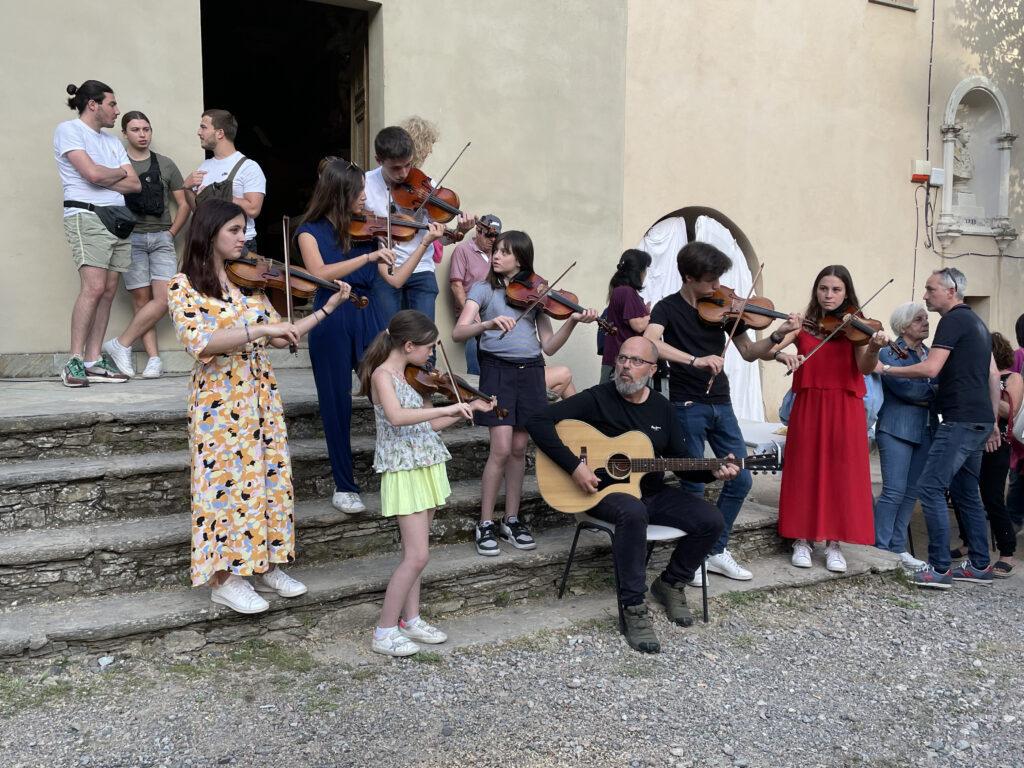 Kids playing violin during I Fochi Paoli 2022 in Morosaglia